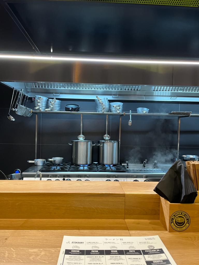 Widok na kuchnię w Ato ramen. Dwa srebrne duże garnki stojące na kuchence